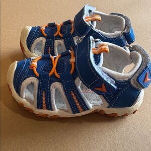 White Apakowa closed toe kids shoes with orange and blue accents
